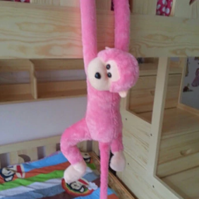 Peluche rose réaliste d'un singe amoureux de câlins